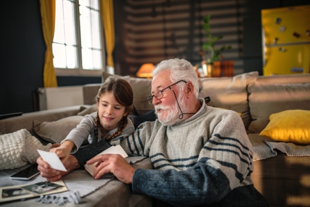 grandfather and little girl looking at photos