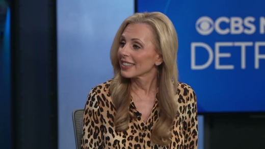 A smiling blonde woman in a leopard print top from a CBS News Detroit broadcast still. The background shows "CBS NEWS DETROIT".